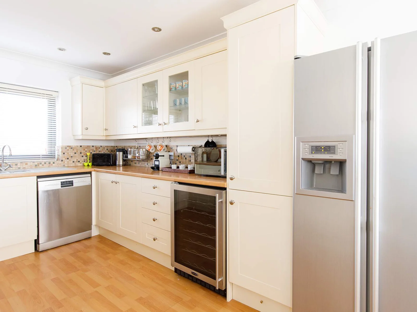 The kitchen has a dishwasher and huge American style fridge freezer.
