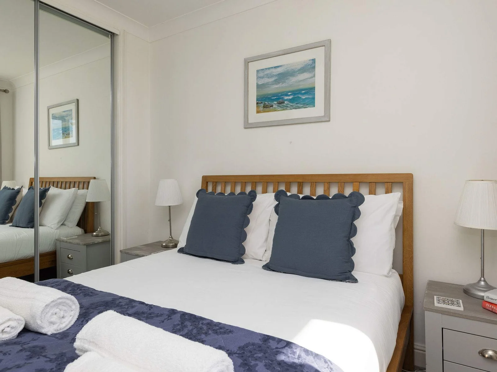 Bright and cosy double bedroom with soft linens, perfect for a relaxing coastal retreat.