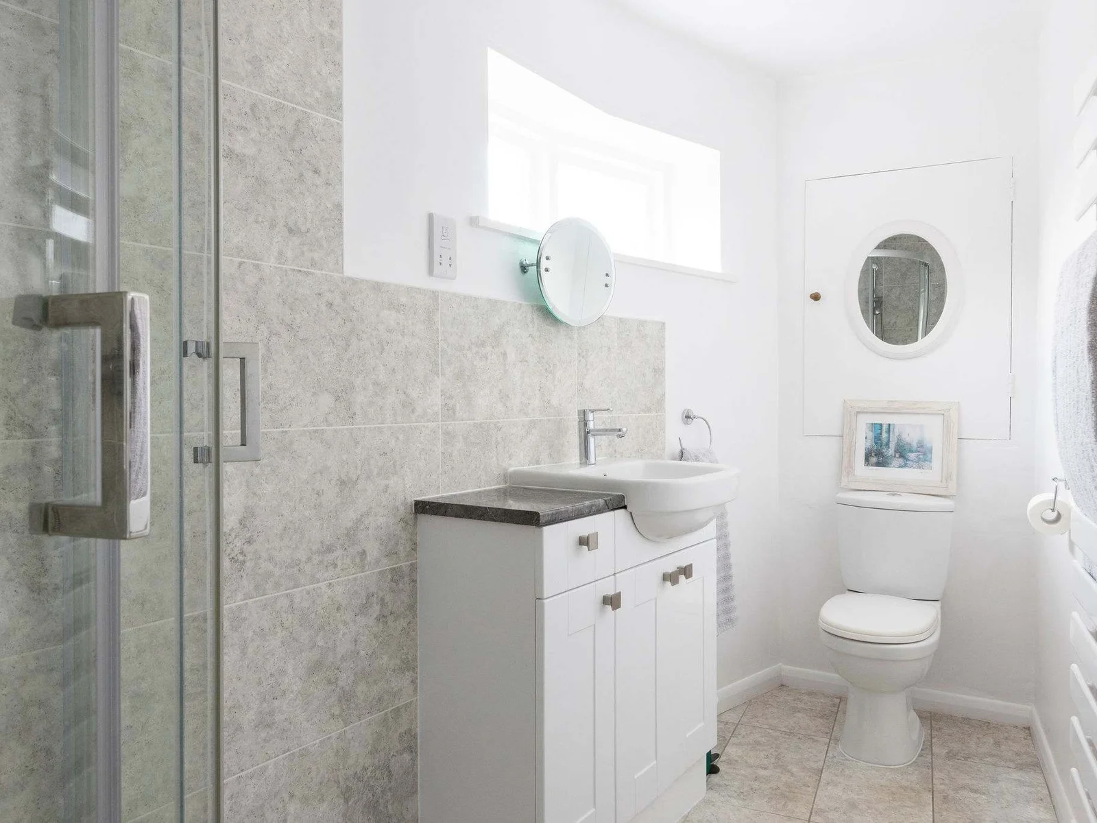A bright bathroom with a walk-in shower and stylish tiling