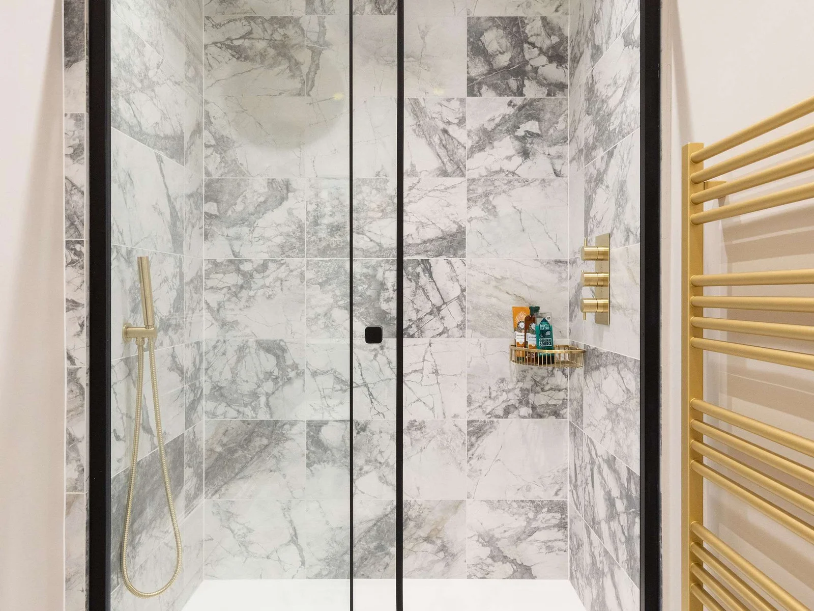 Sleek walk-in shower with luxury marble tiles