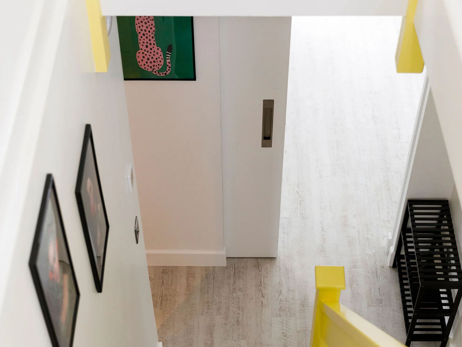 Bright and inviting staircase area with a pop of yellow on the railing