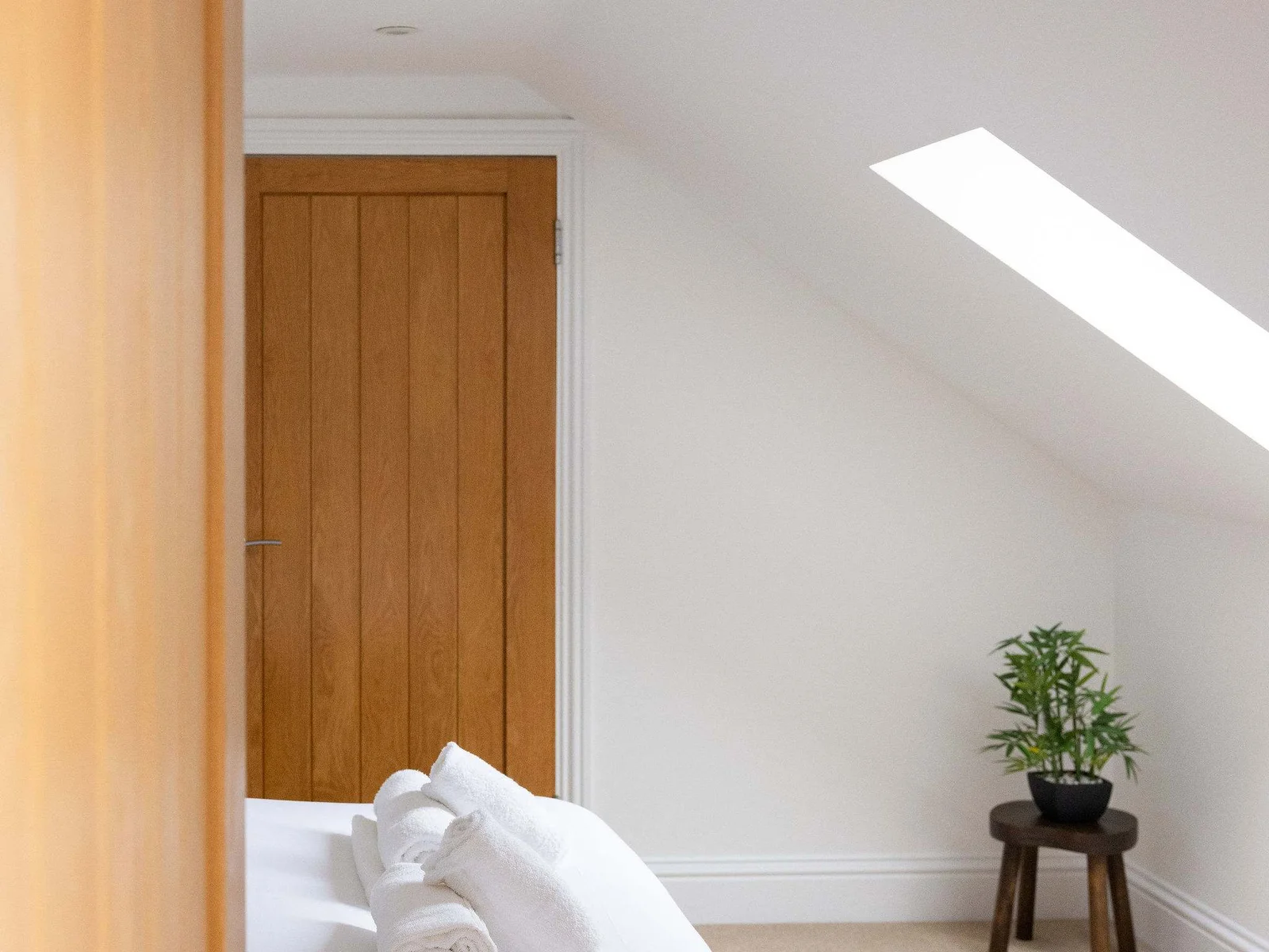This second top-floor bedroom has its own tucked-away charm, with a generous sense of space beneath the eaves and a skylight bringing the countryside light in from above.
