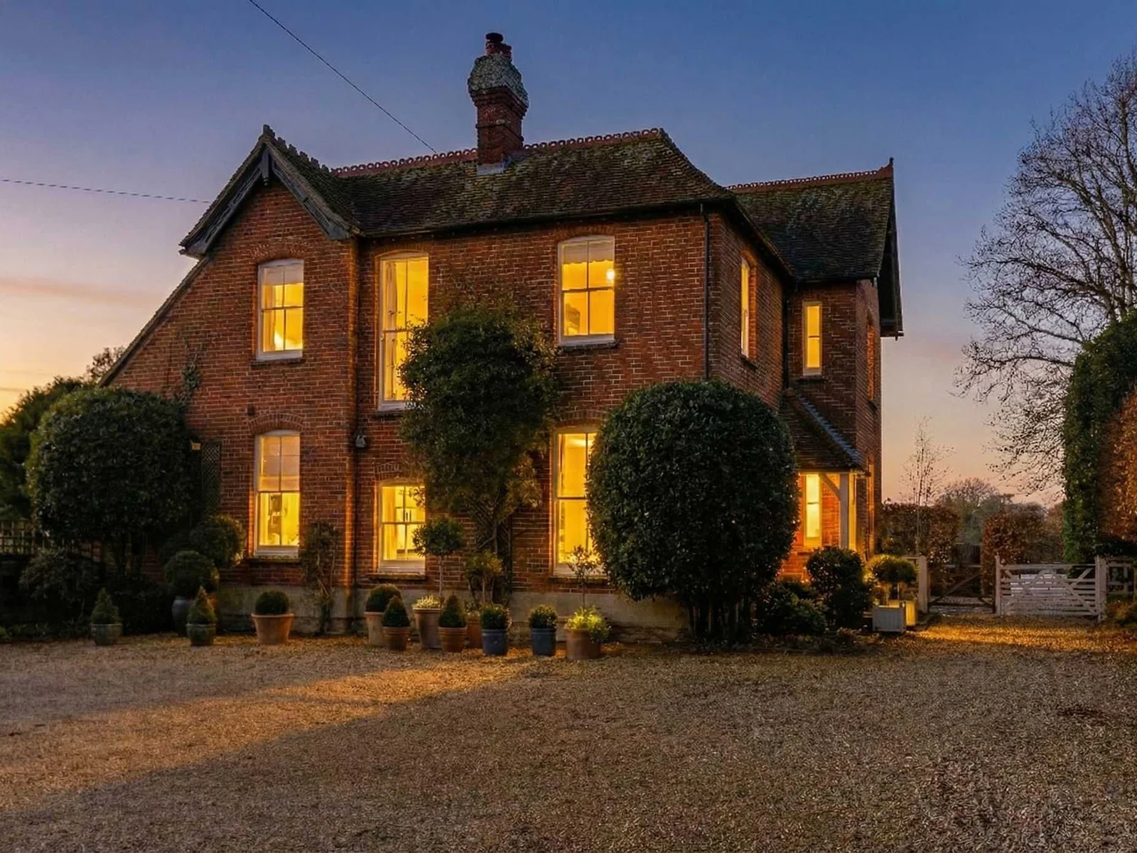 Beautiful countryside home glowing warmly at dusk.