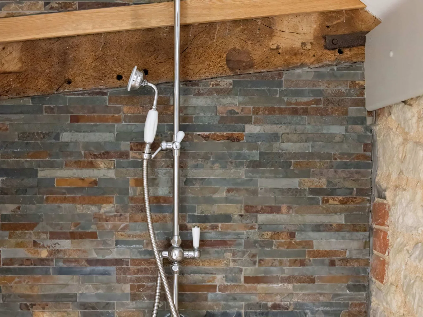 Refresh under the generous rainfall shower with beautiful natural stone detailing.