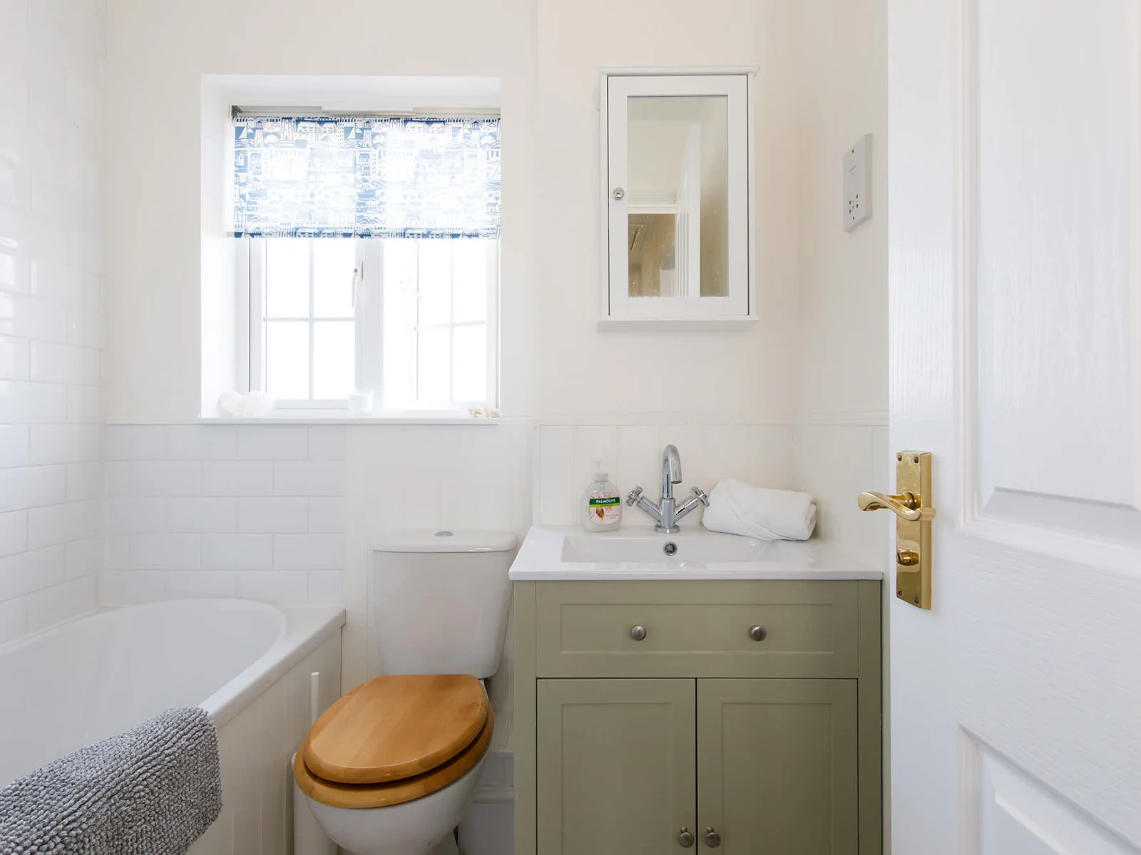 The family bathroom has a bath with overhead shower, WC and sink.