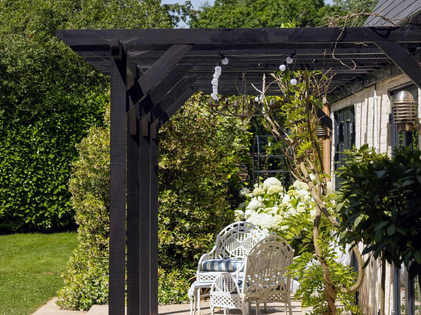 Covered patio framed by climbing greenery, creating a charming spot to unwind outdoors