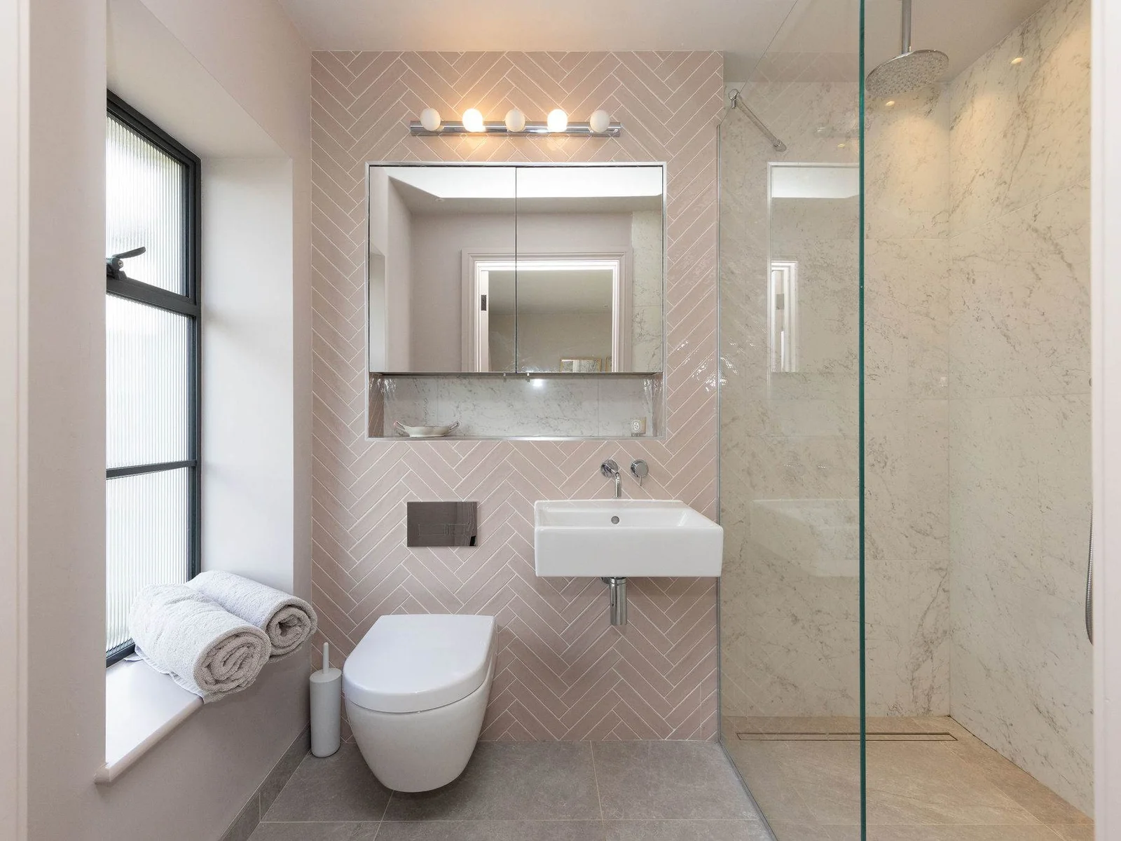 Beautifully tiled bathroom with walk-in shower, contemporary fixtures, and a sleek modern finish.