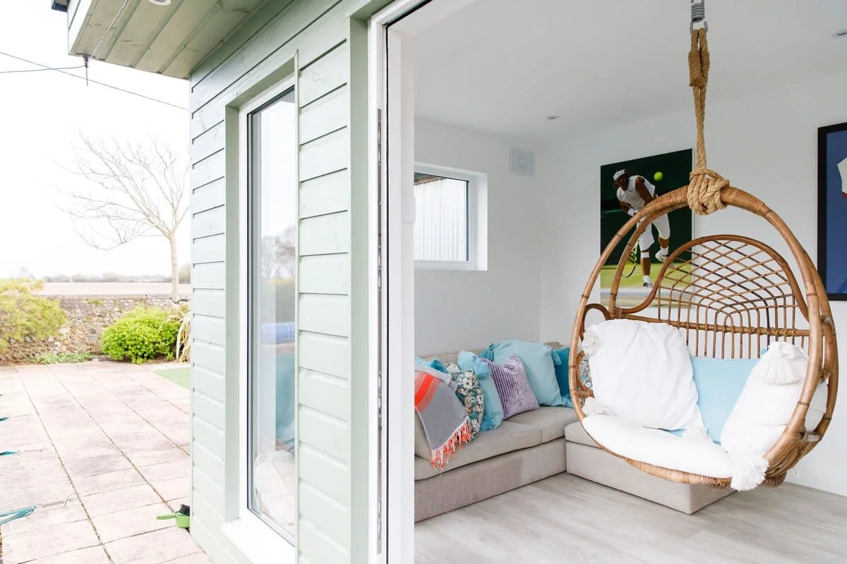 The separate home gym has a comfy egg seat and corner sofa.