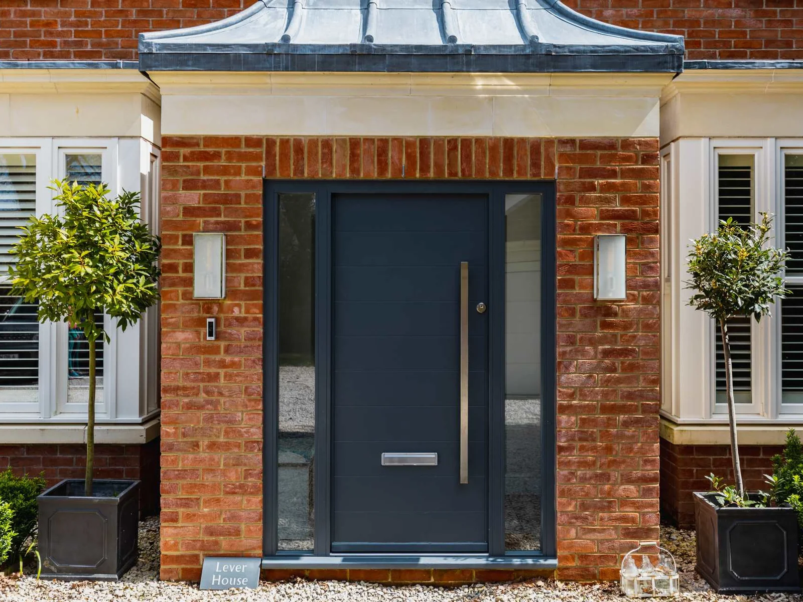 Elegant front entrance with modern door and landscaped details, creating a stylish first impression.