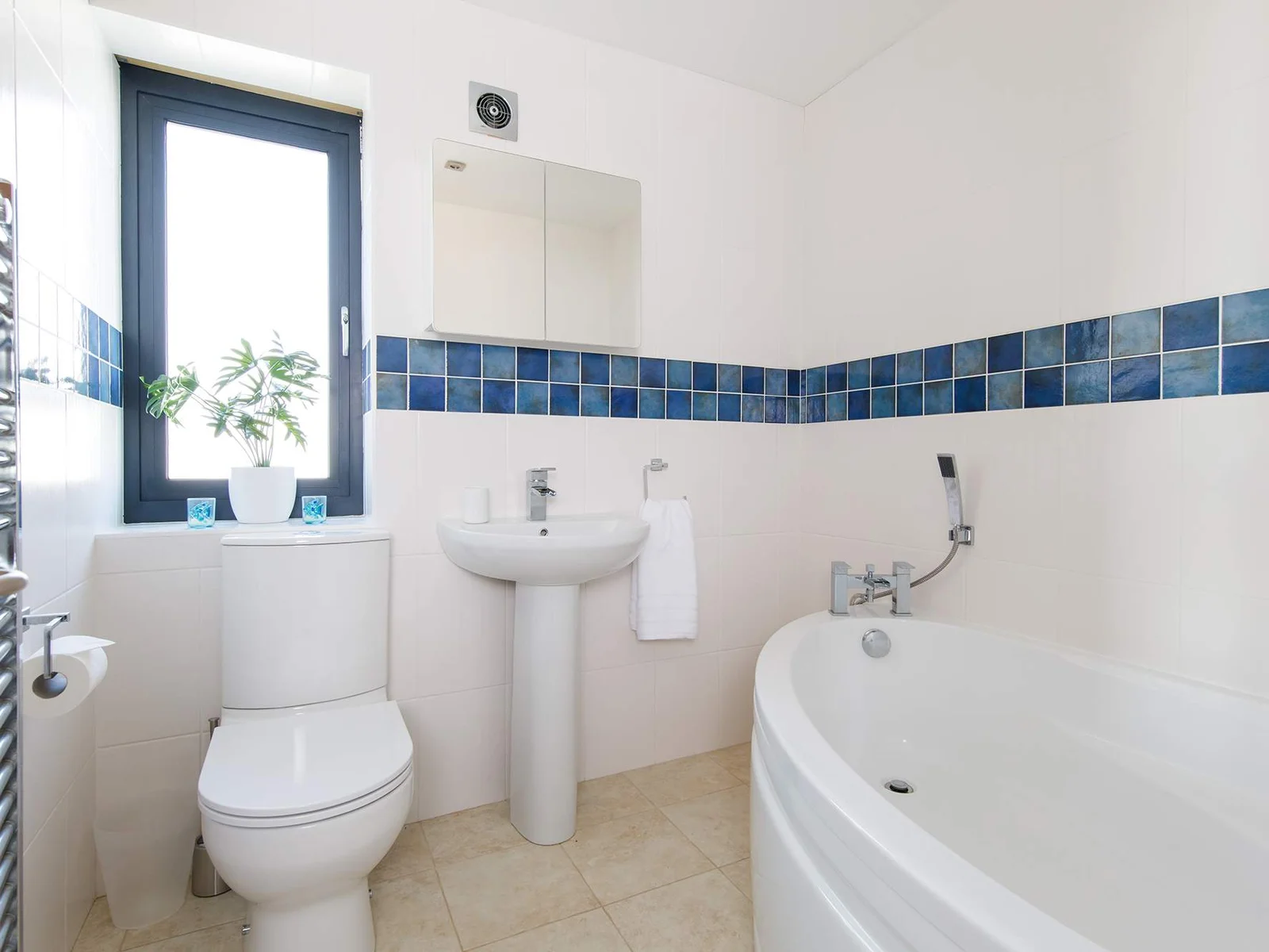 The family bathroom has a large bath, WC and sink.