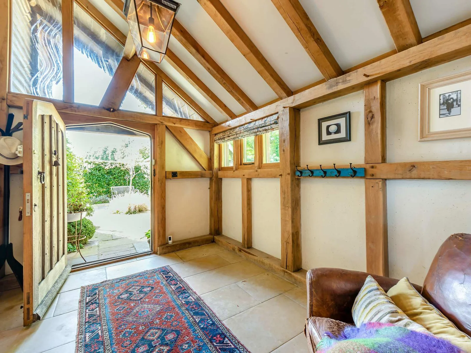 A warm, characterful entrance with exposed oak framing and doors onto the courtyard