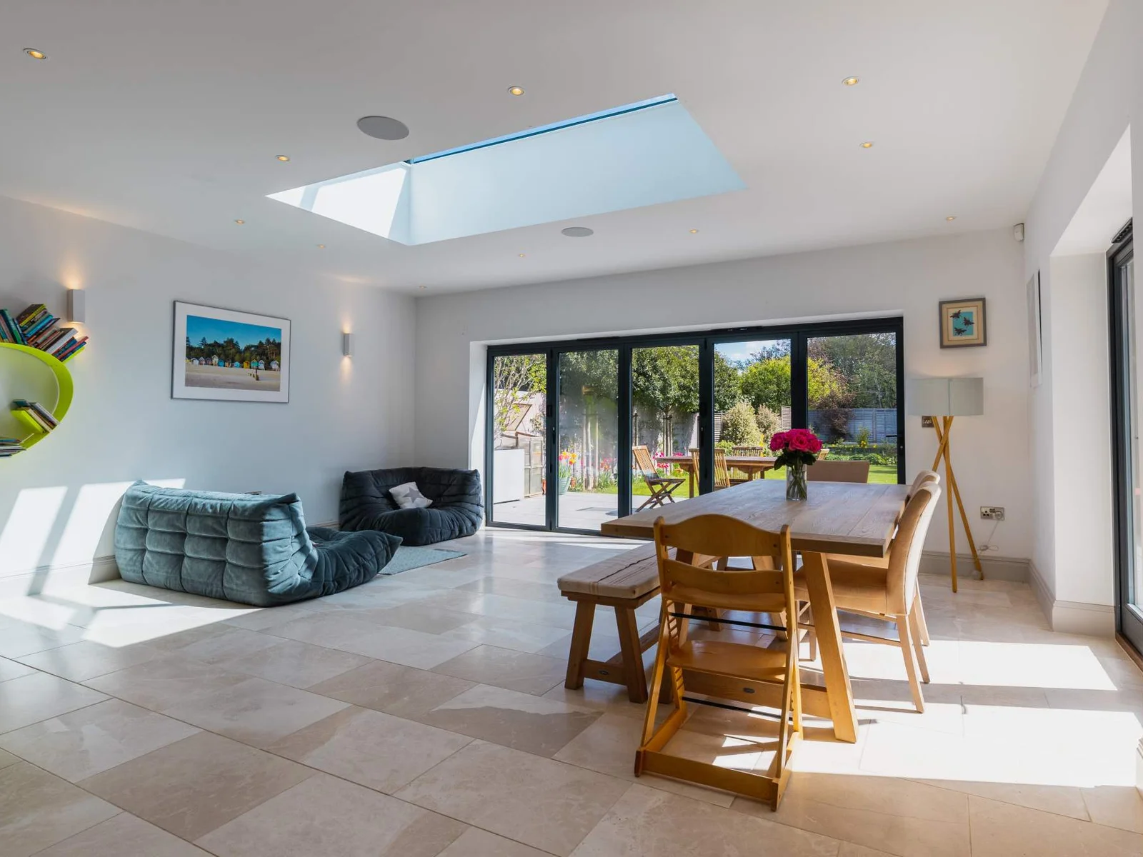 Bright open-plan dining and living space with skylight and garden-facing bi-fold doors.