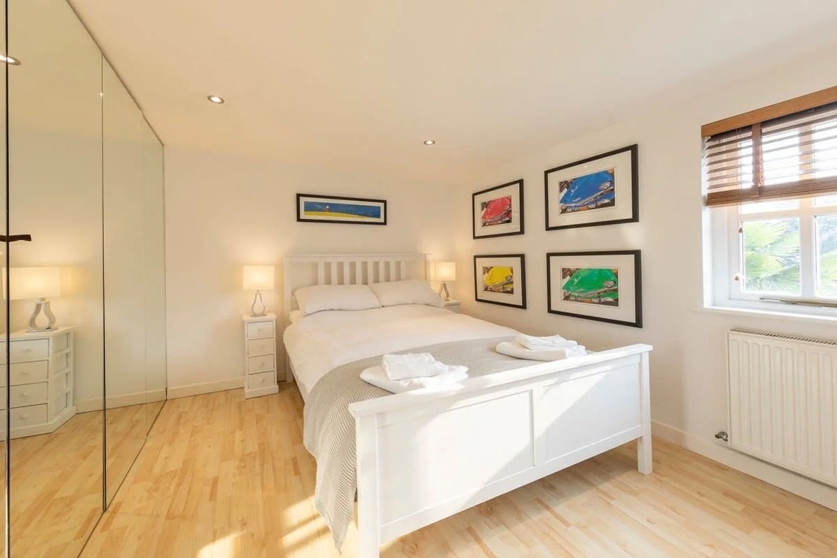 A double bedroom has a very large full mirrored wardrobe for your belongings.