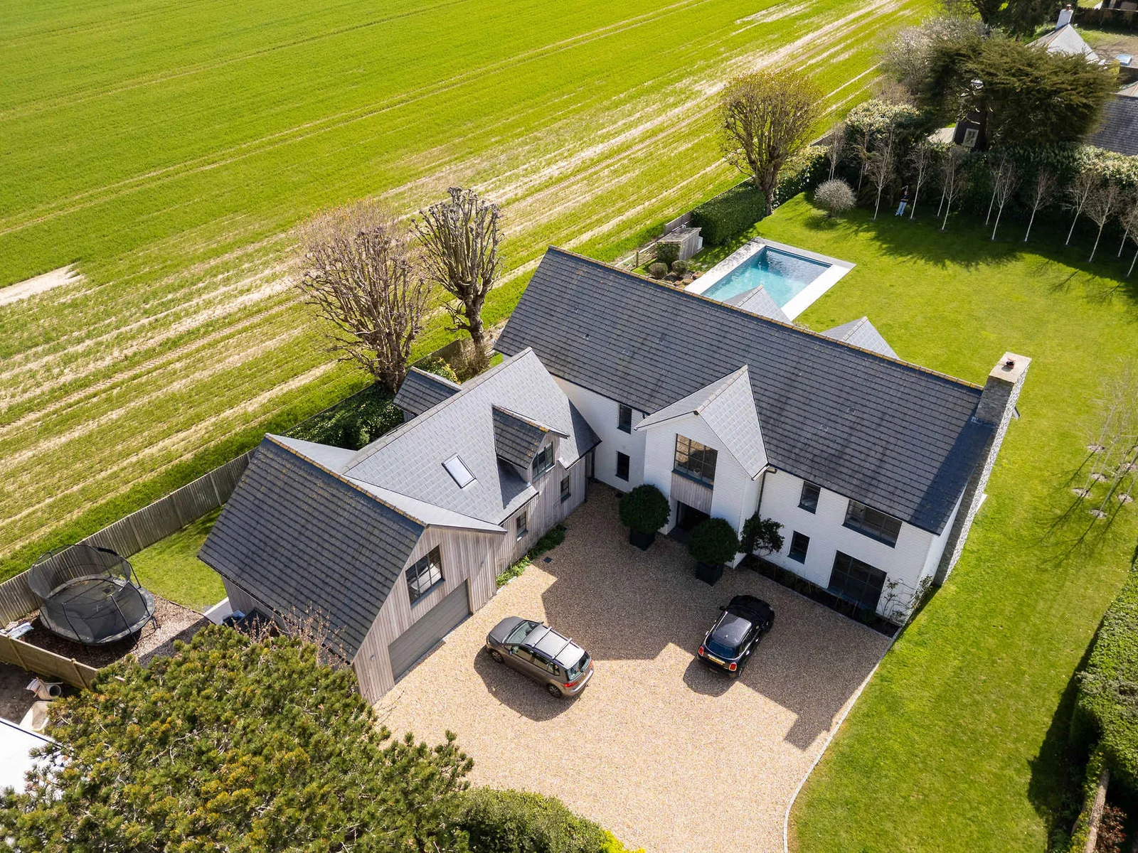 Aerial perspective showing the stunning property with private parking, pool, and countryside surroundings.