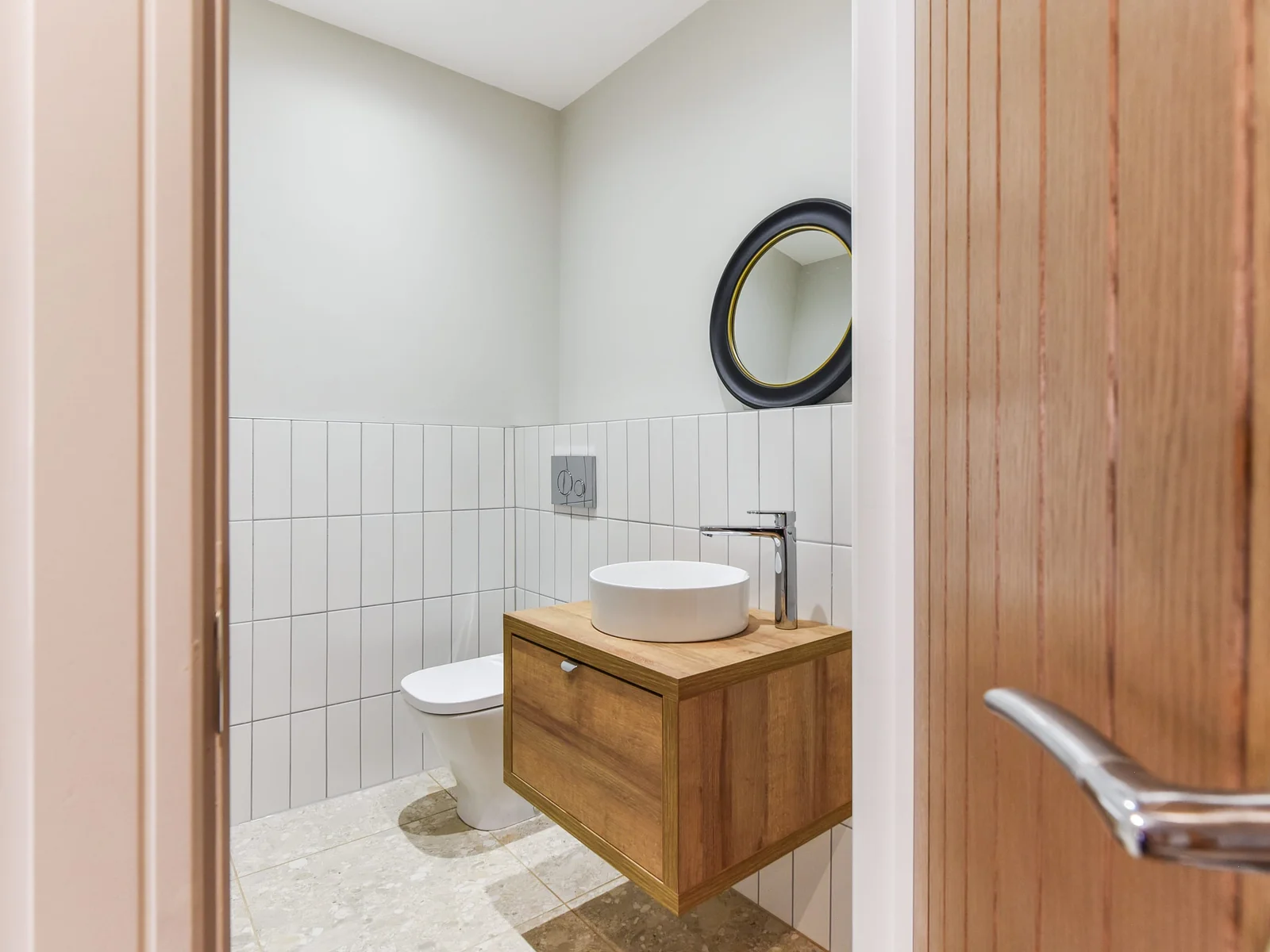 An ensuite shower room with sink, overhead mirror & WC.