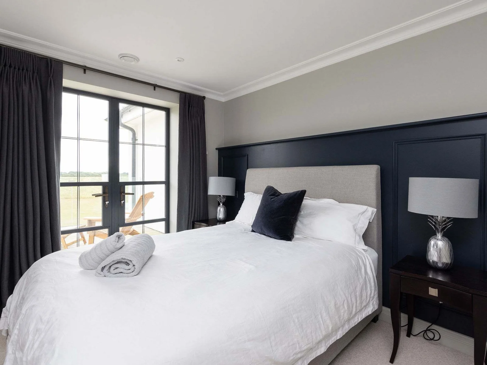 Sleek double bedroom with sofa bed and countryside views