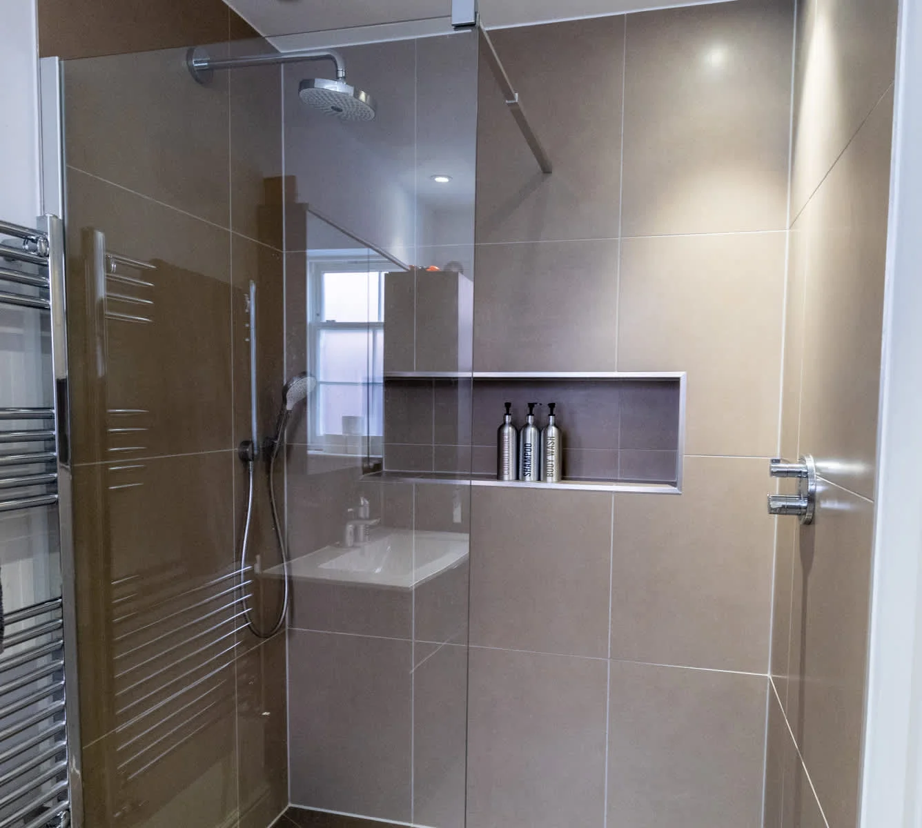 Modern tiled shower room with glass enclosure and stylish fittings.