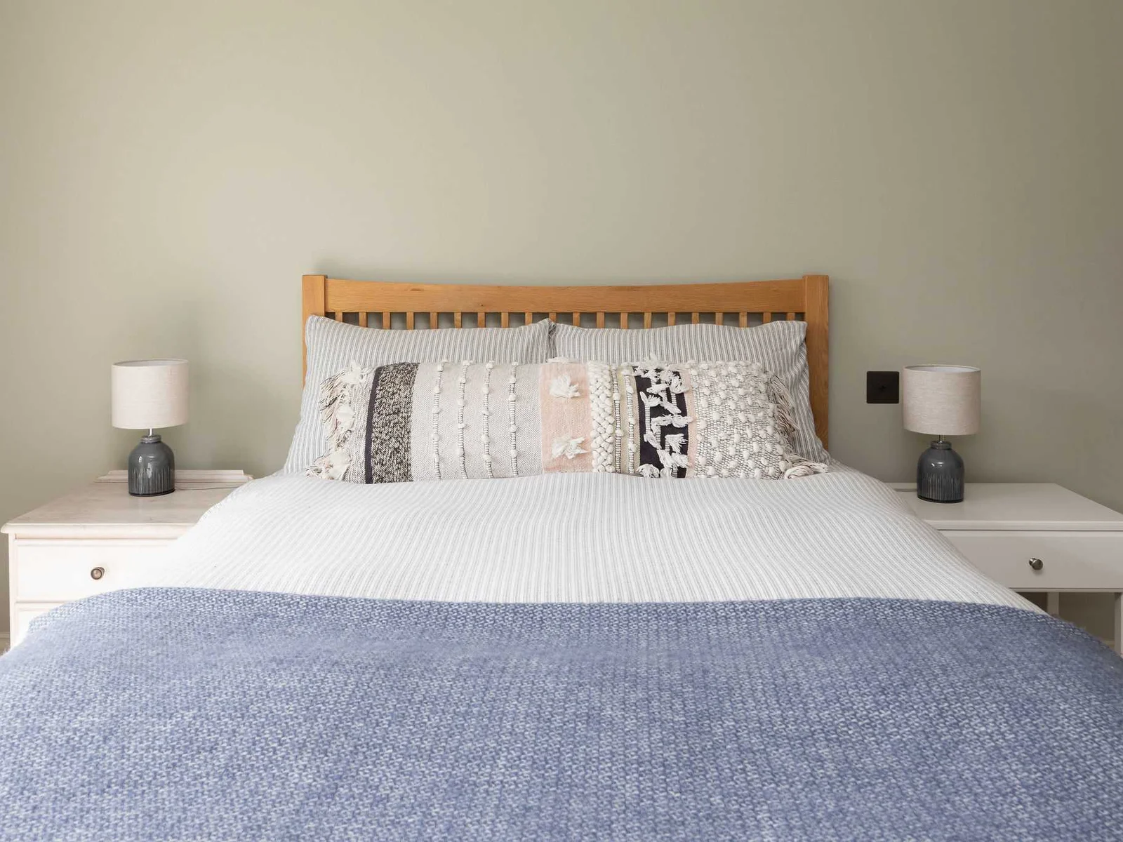 Comfortable and inviting with quality linens, patterned cushions, and a clean, modern style.