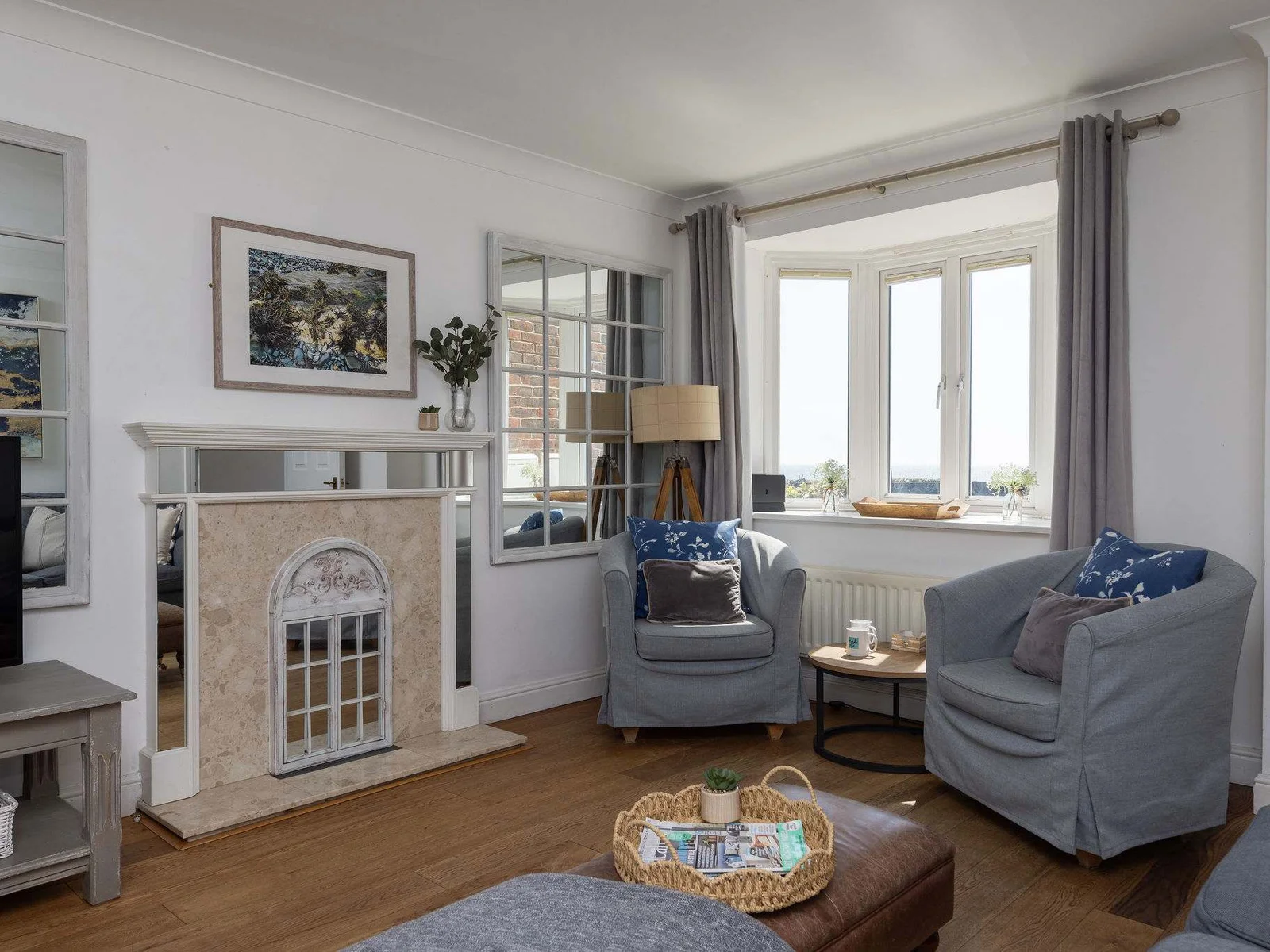 Bright and spacious living room with cosy seating and beautiful panoramic ocean views.