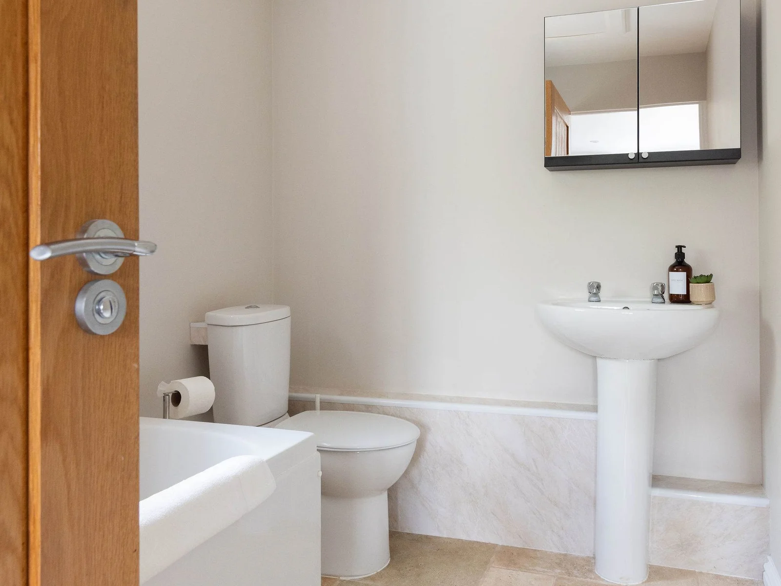 A beautifully finished private en-suite with a full-size bath, soft neutral tones and a bright, peaceful feel — a lovely space to start or end the day.