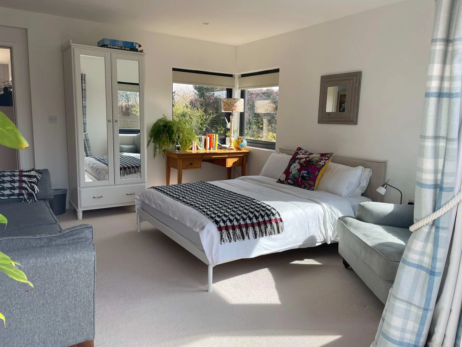 Bedroom 2 is a spacious king room, with sofa, side tables, lamps and throws.