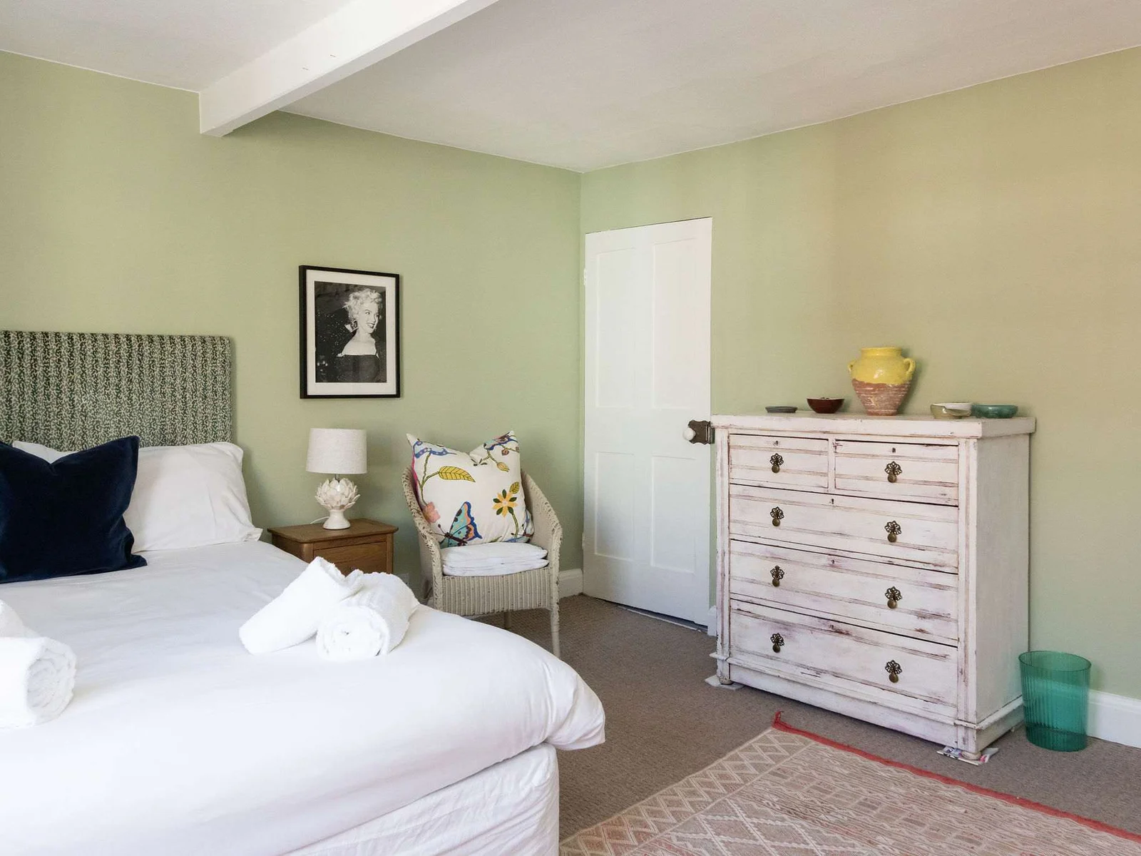 Spacious green bedroom with fireplace and calming vintage style