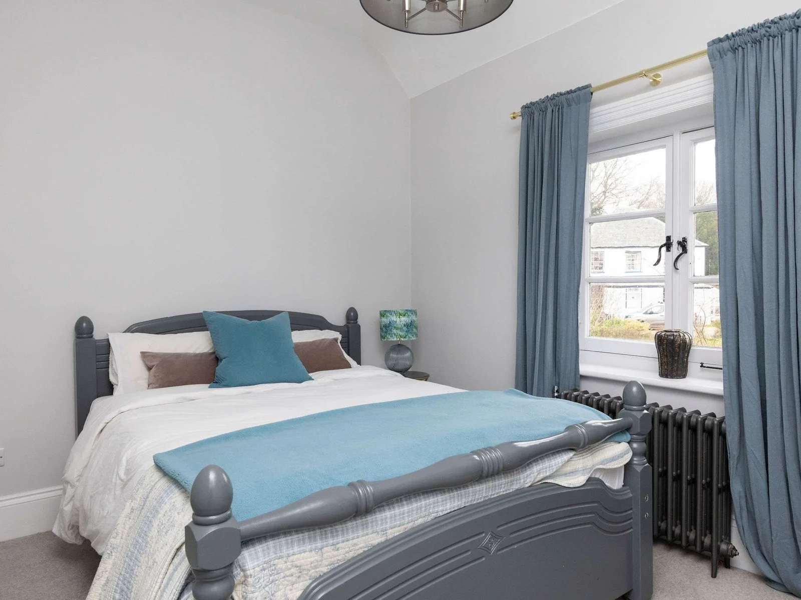 A cosy king bedroom with rich blue tones and soft textures