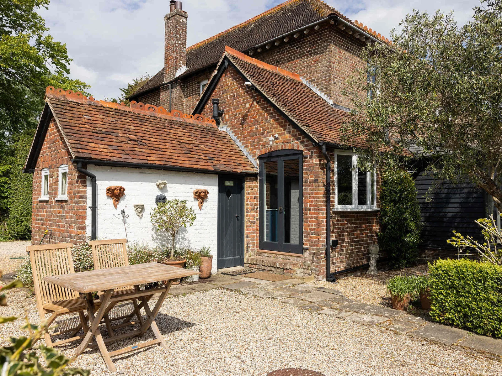 Charming exterior with private outdoor seating area.