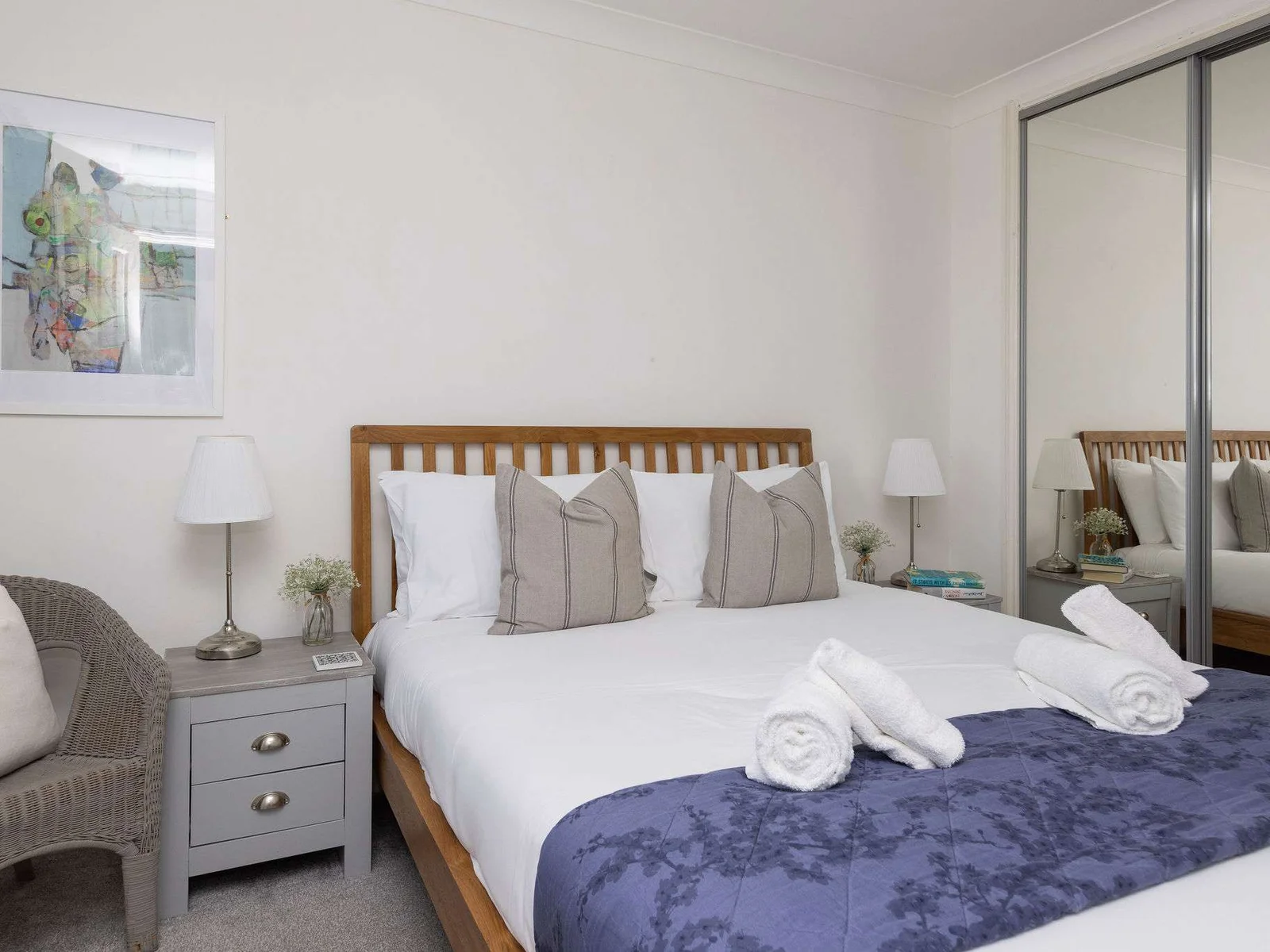 Bright and comfortable bedroom with mirrored wardrobes, offering a stylish and spacious retreat.