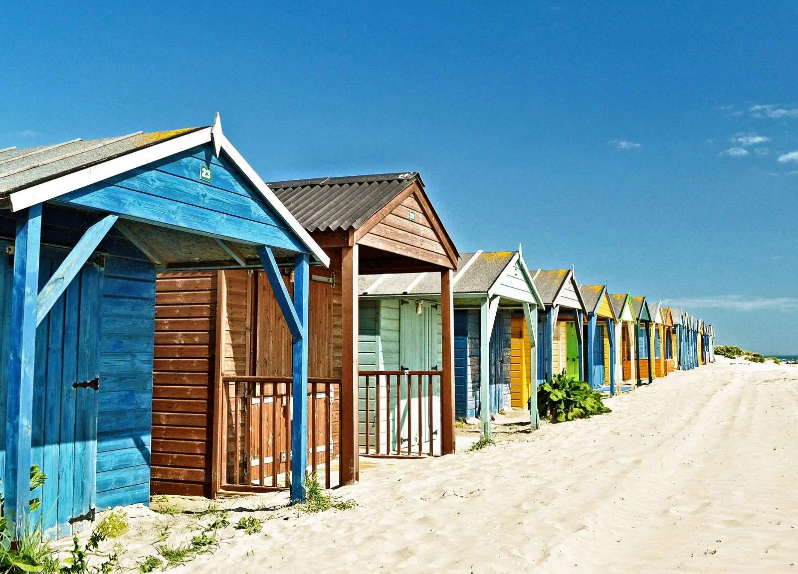 Iconic colourful beach huts lining the award-winning Blue Flag sands