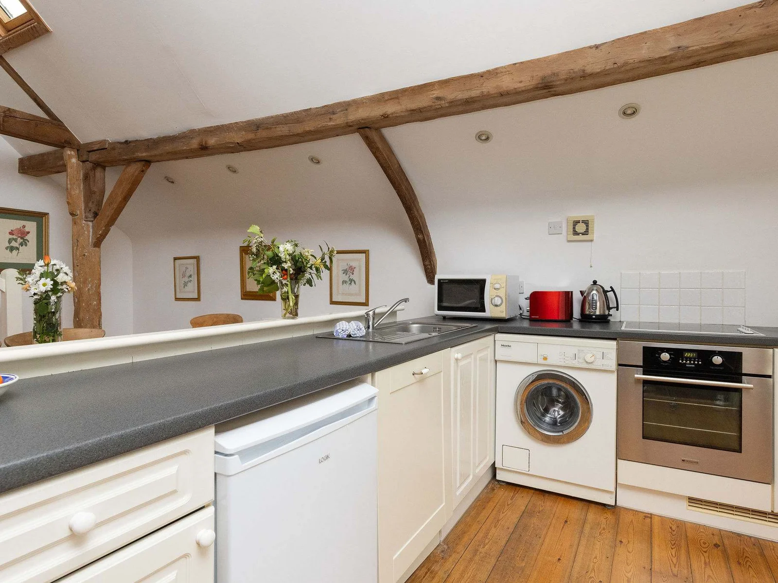 The kitchen in Wren Barn features plenty of prep space and all the essentials, including a oven, microwave, kettle and toaster.