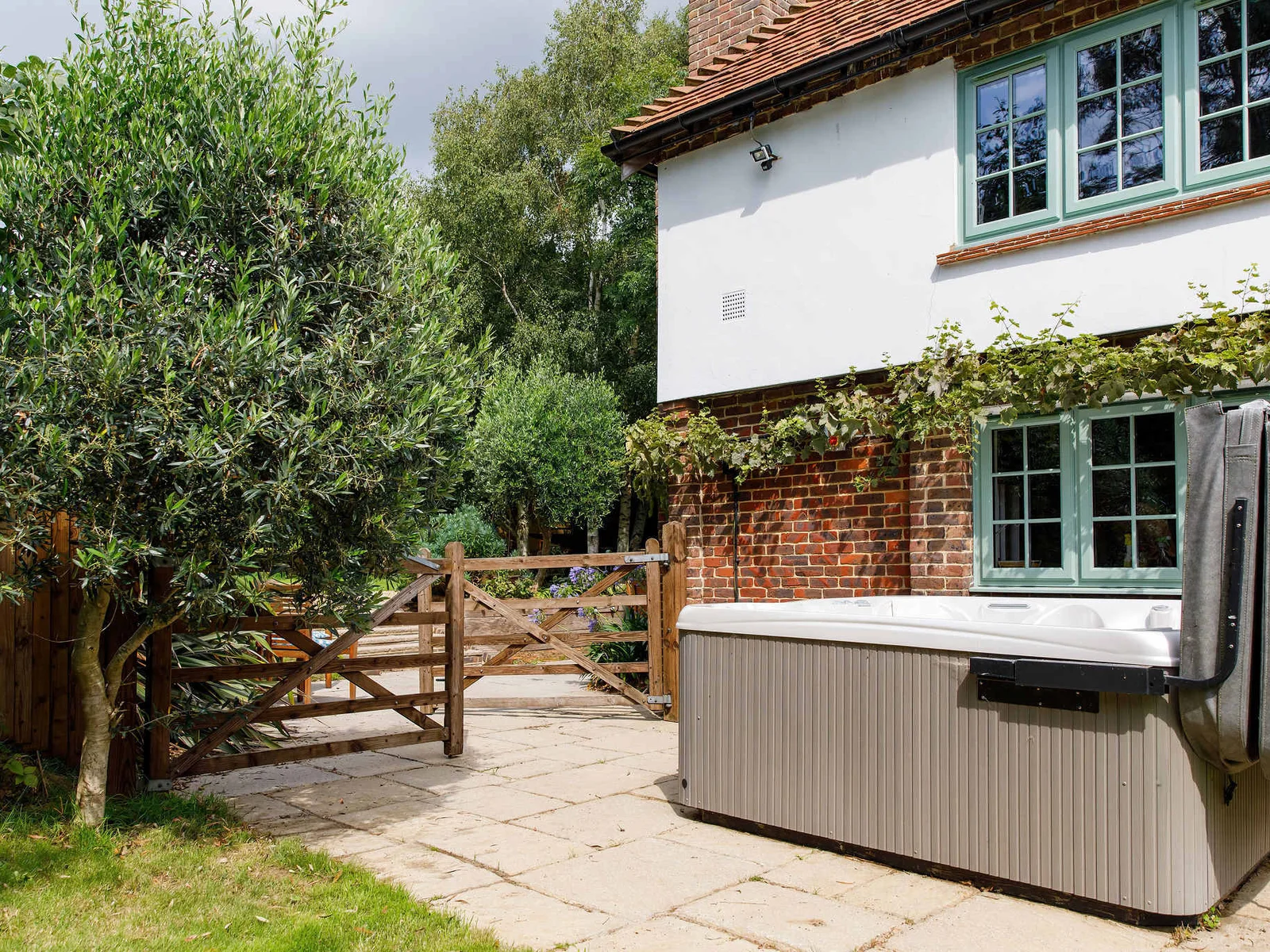 The hot tub is tucked around the side of the house, by the kitchen.
