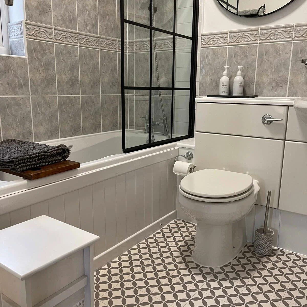 The family bathroom has a bath with an overhead shower, WC and sink.