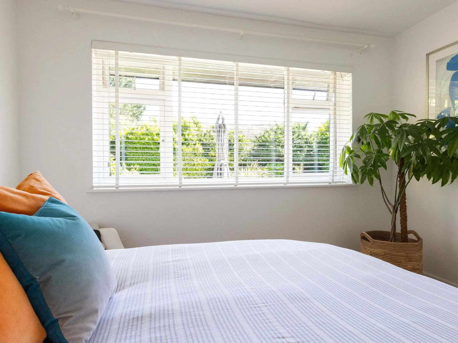 Garden views and soft colours create a relaxed bedroom feel