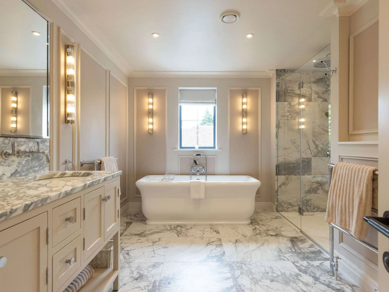 Soak in style in the marble-clad, spa-like en suite bathroom