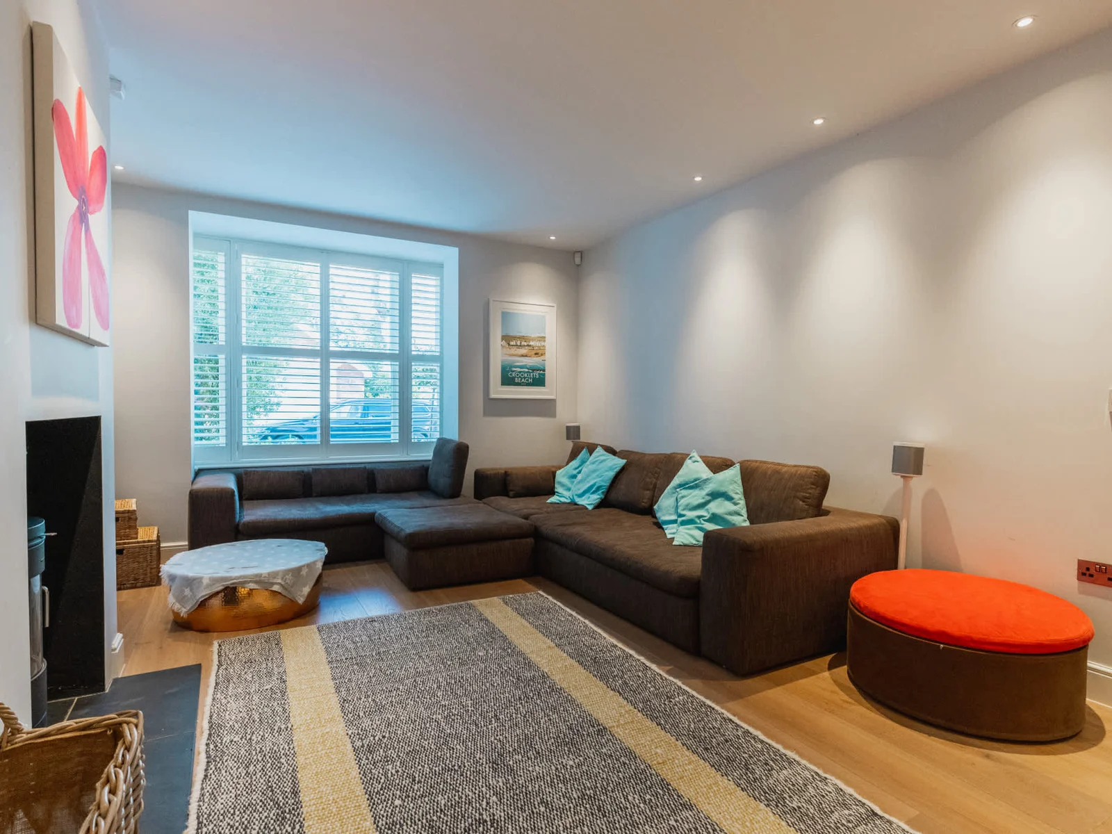 Cosy lounge with large sectional sofa, Smart TV and log burner—perfect for relaxing after a day exploring Chichester.