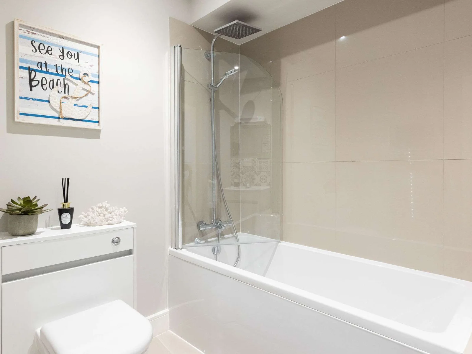 Bright family bathroom with shower over bath, perfect for relaxing after beach adventures