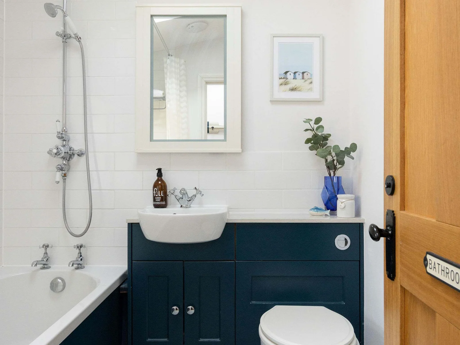 Stunning blue floor tiles paired with sleek black paneling bring a bold, sophisticated touch to this bathroom.