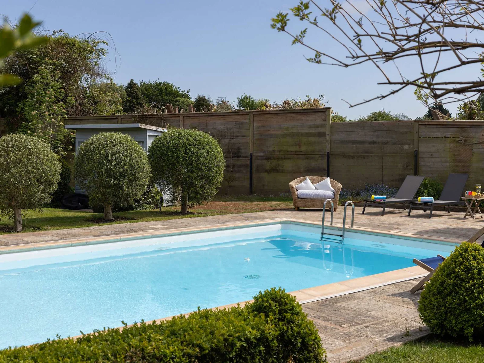 Heated outdoor pool surrounded by peaceful garden space.