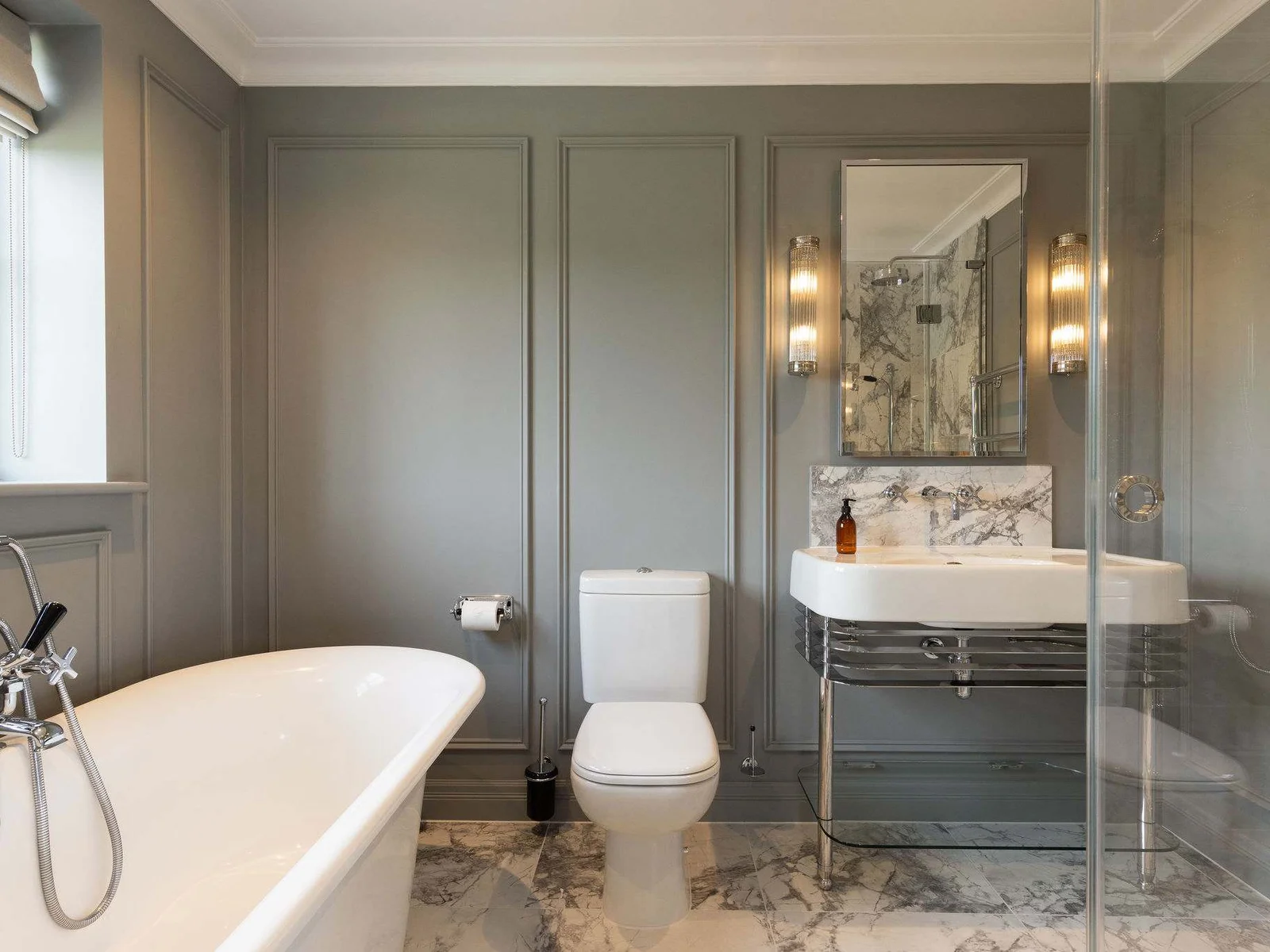 Elegant bathroom with marble flooring and panelled walls