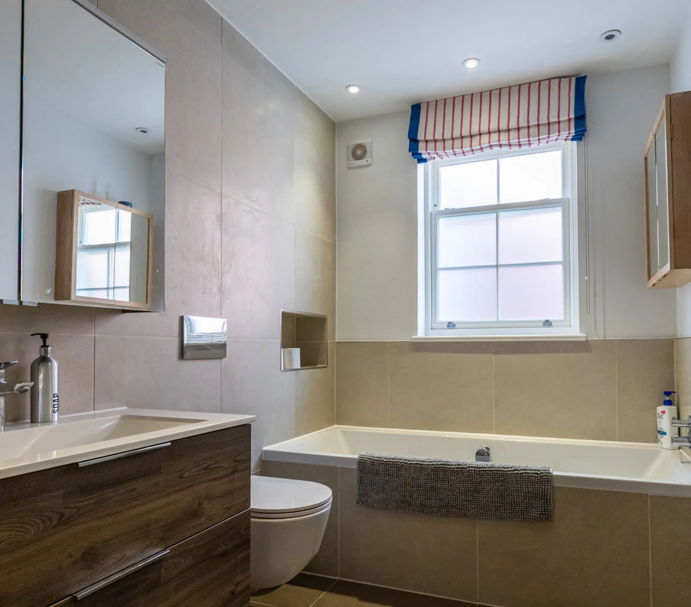 Modern bathroom with bathtub, sleek vanity and contemporary finishes for a relaxing stay.