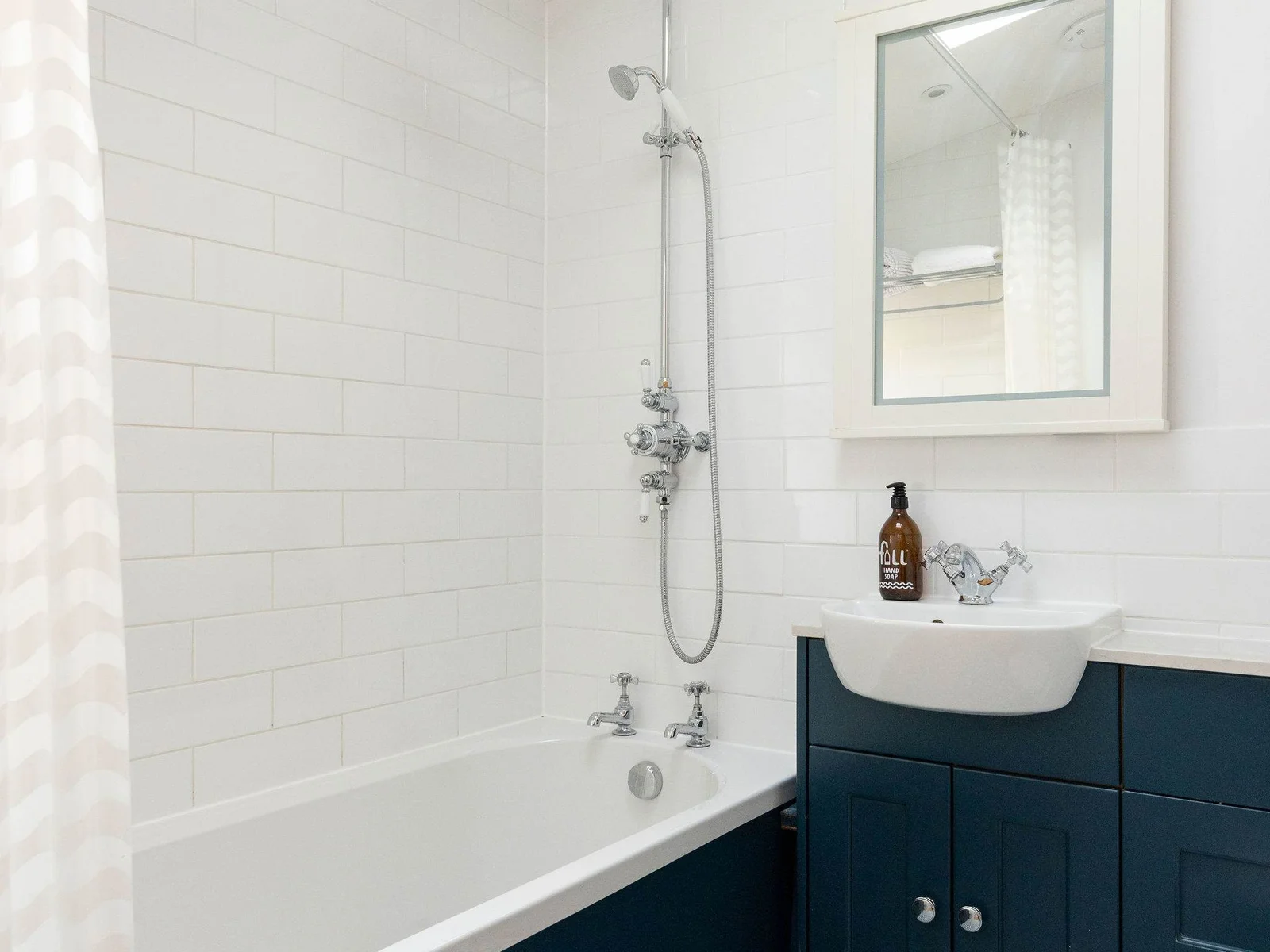 The family bathroom features a bath with an overhead shower.