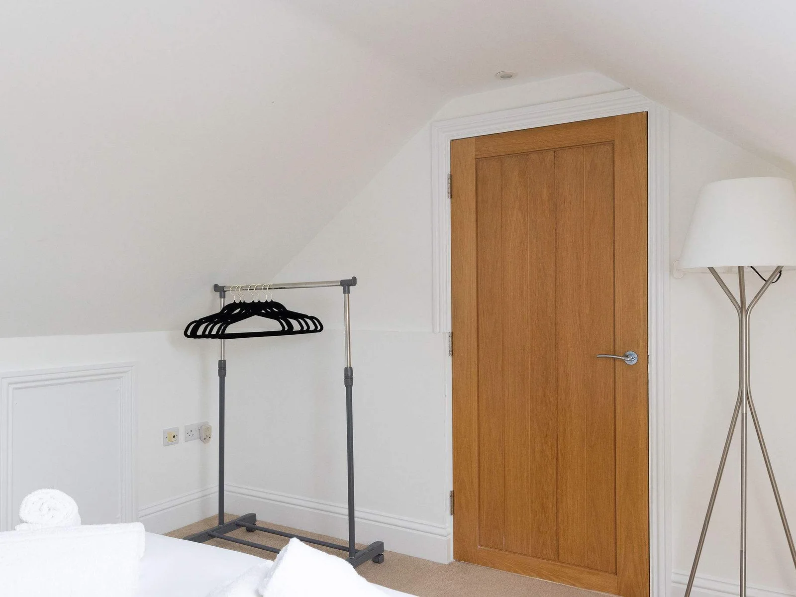 Useful hanging space and a full-length floor lamp add practical touches to this top-floor double, while the sloped ceiling keeps the room feeling cosy and characterful.