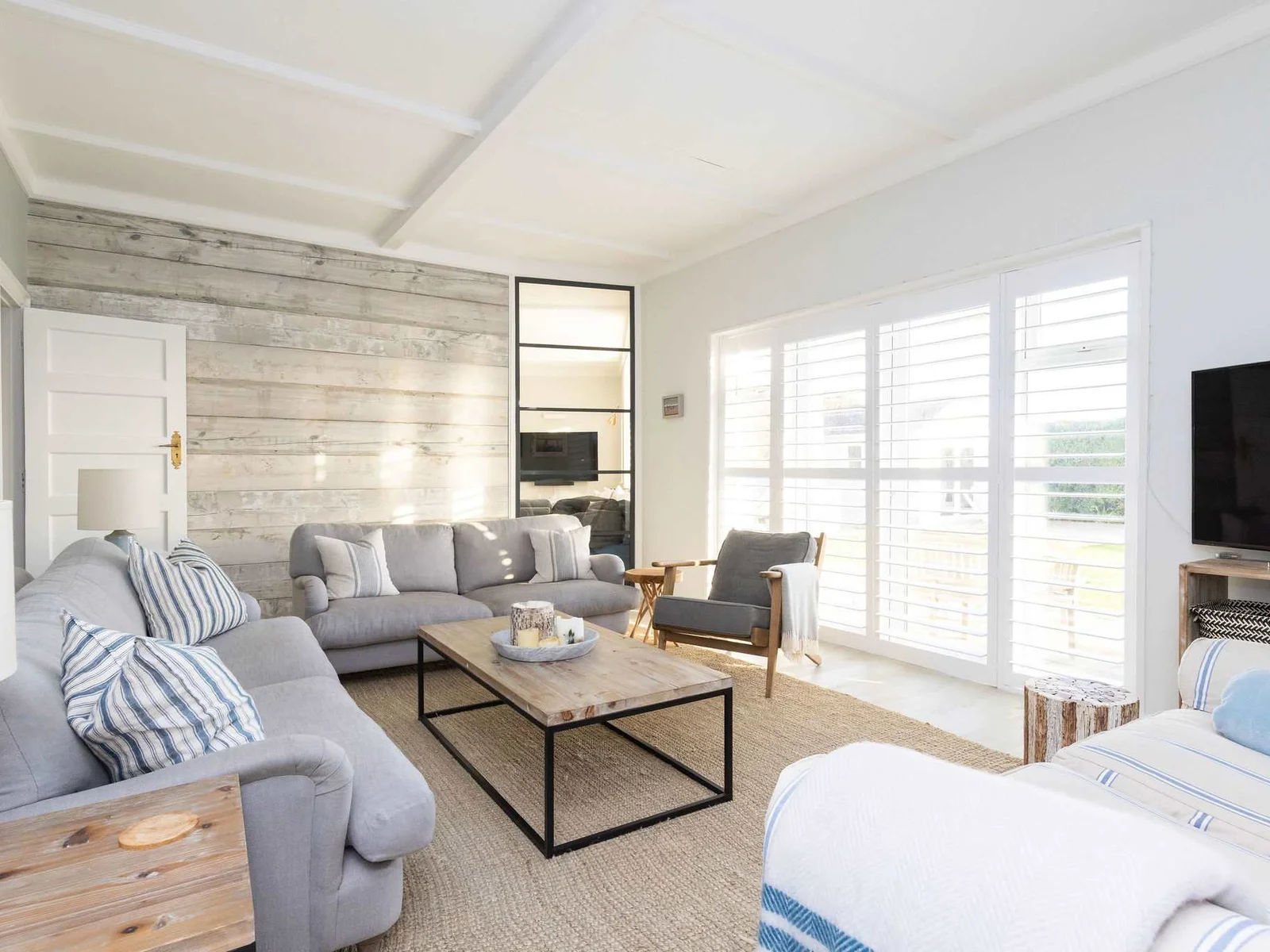 Sun-filled living area with garden access & TV.