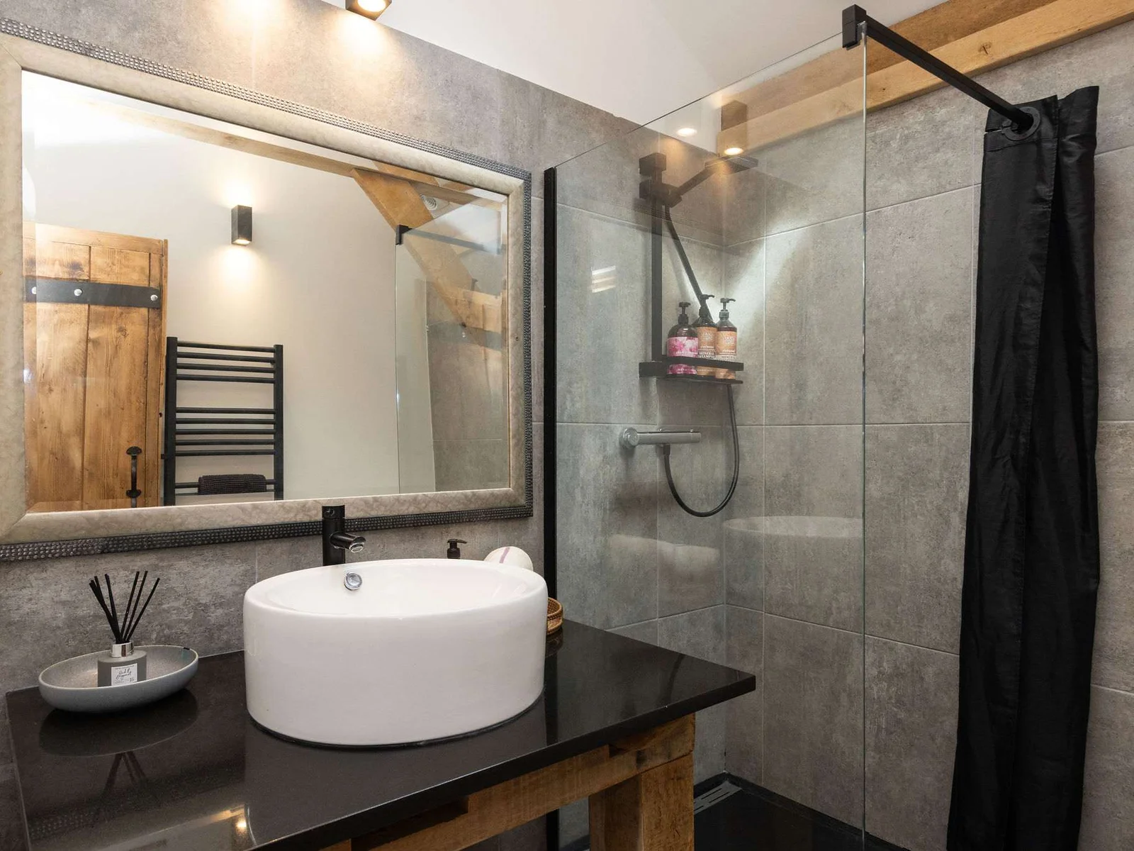 Experience spa-like luxury in this contemporary full bathroom with beautiful stone and wood accents.