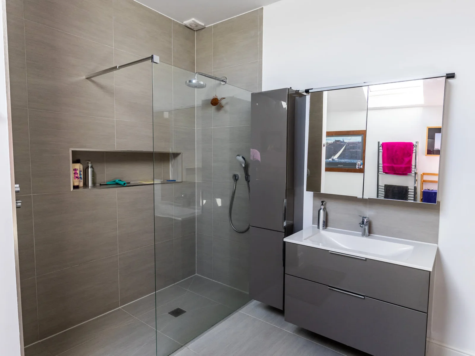 Modern bathroom with walk-in glass shower, sleek vanity and contemporary finishes.