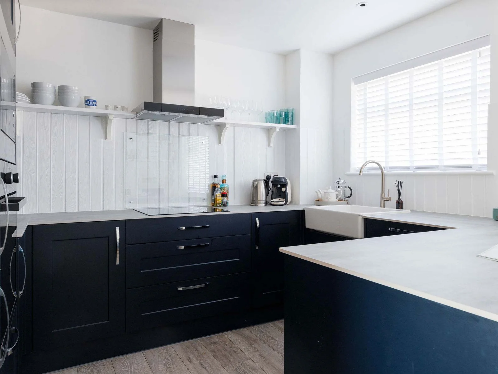 Modern kitchen with sleek navy cabinets and full amenities