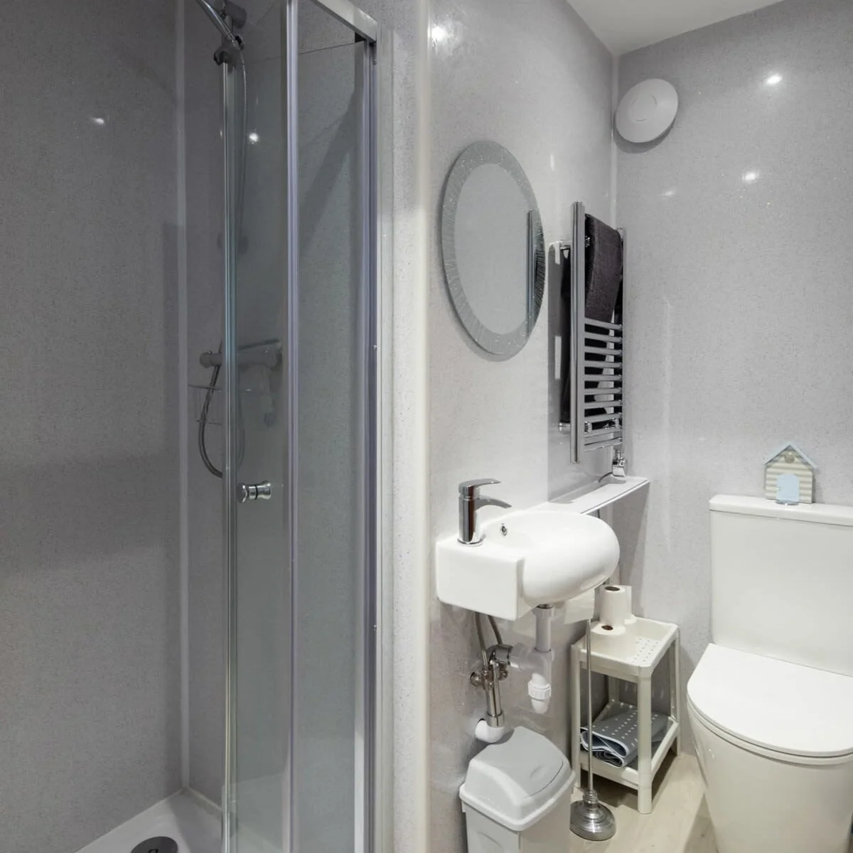 The modern upstairs bathroom with a walk in shower and a heated towel rail