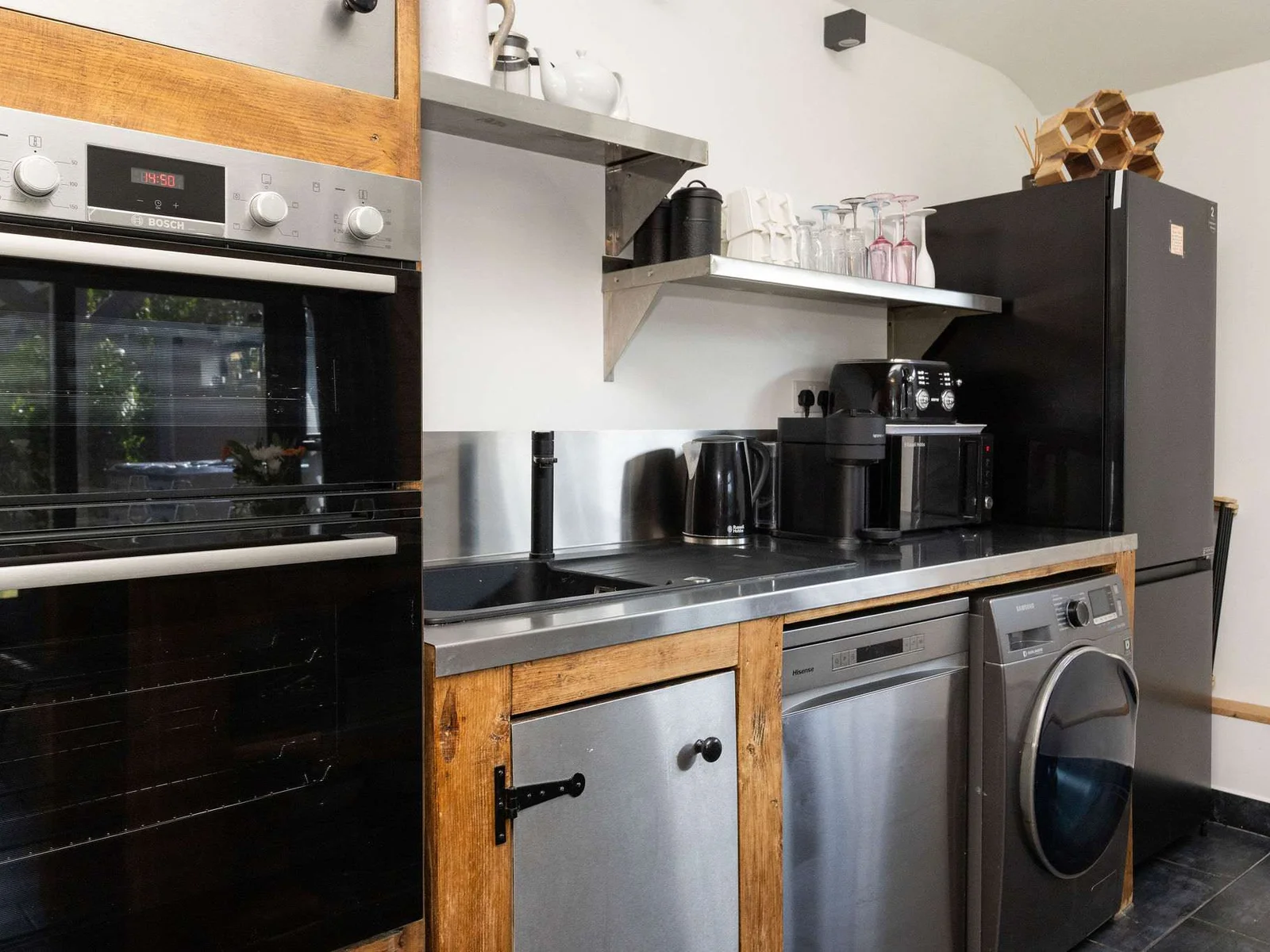 This contemporary kitchen setup boasts high-end appliances perfect for a premium holiday rental experience.