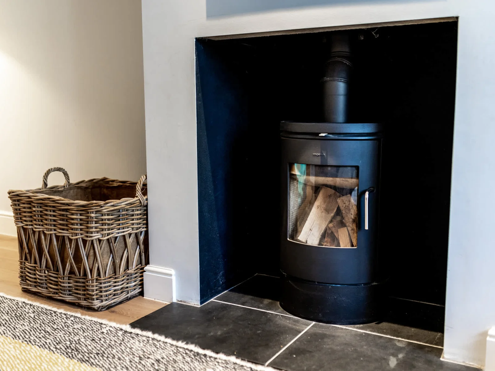 Modern wood-burning stove set in a sleek fireplace, perfect for cosy evenings after exploring Chichester.